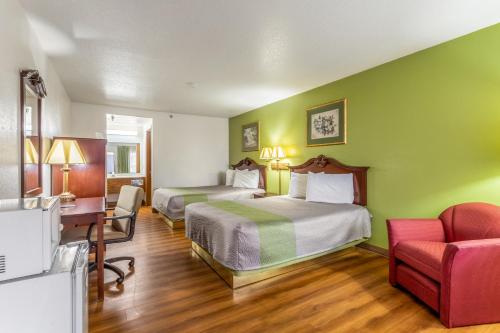 a hotel room with two beds and a desk and a chair at Rodeway Inn in Santa Rosa