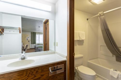 a bathroom with a sink and a toilet and a mirror at Rodeway Inn in Santa Rosa