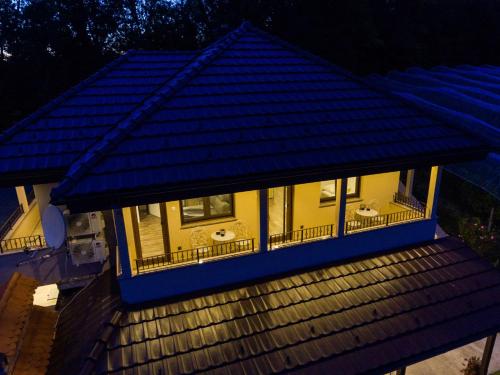 a yellow house with a blue roof at Apartmani Petra i Tea in Krapina