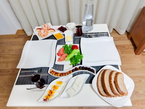 a table with a breakfast of bread and vegetables at Upart Home in Mersin