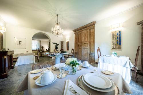 a dining room with tables and a chandelier at La Casa nel Borgo in Piadena