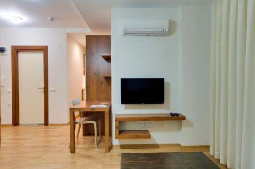 a room with a desk with a television on a wall at Upart Home in Mersin