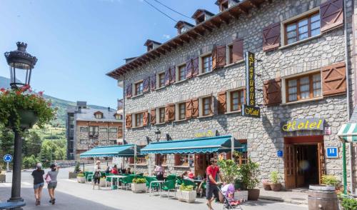 un groupe de personnes marchant devant un bâtiment dans l'établissement Hotel Aragüells, à Benasque