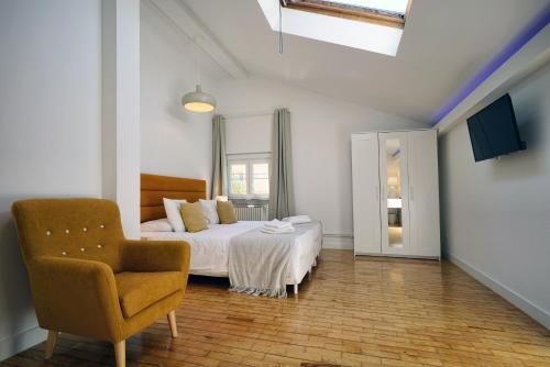 a bedroom with a bed and a chair in it at Comfy Sintra in Sintra