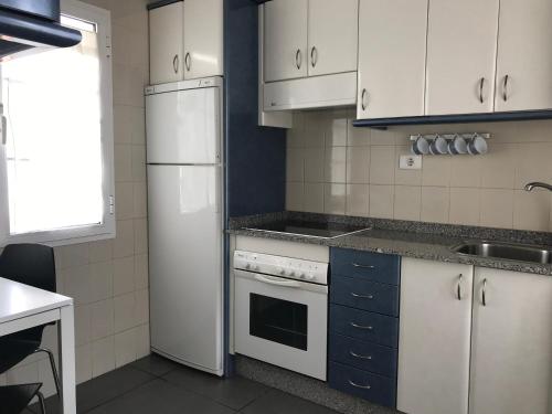 uma cozinha com electrodomésticos brancos e armários azuis em Apartamento Playa Blanca Holiday em Puerto del Rosario
