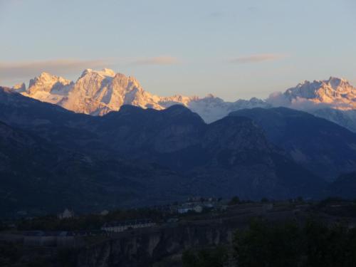 Un groupe de montagnes où le soleil brille dans l'établissement La Bonne Auberge, à Risoul