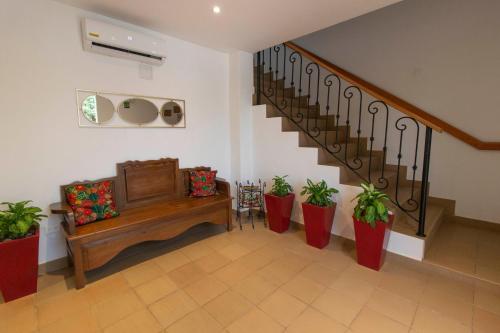 a living room with a staircase with potted plants at Hotel La Gloria in Mompos