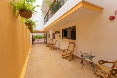 a corridor of a house with chairs and a table at Hotel La Gloria in Mompos