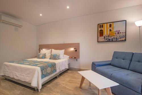 a bedroom with a bed and a blue couch at Hotel La Gloria in Mompos