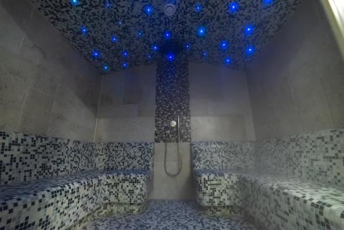 a bathroom with a shower with blue lights at Hotel Kostelski Buk in Bihać