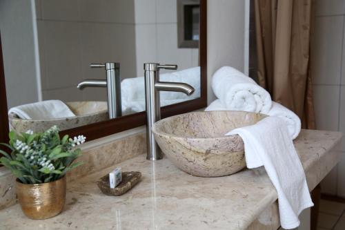 uma casa de banho com um lavatório em mármore e um espelho. em Casa Celia Hotel Restaurante em Bernal