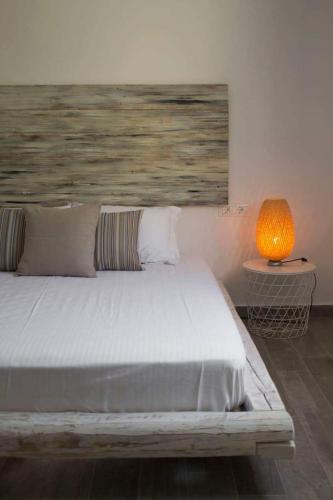 a bedroom with a bed and a lamp on a table at VILLA AKTI in Mochlos