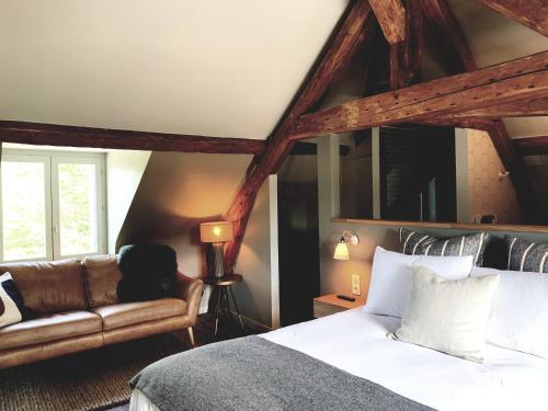 a bedroom with a bed and a couch at Domaine les Bruyères in Gambais