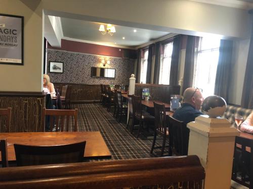a woman sitting at a table in a restaurant at Black Dog Inn in Bolton