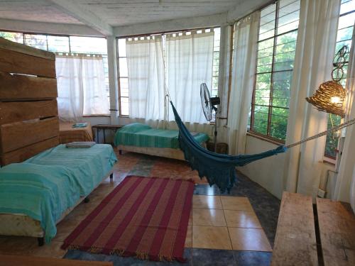 una camera da letto con amaca in una stanza con finestre di Scenario Yguazu a Puerto Iguazú
