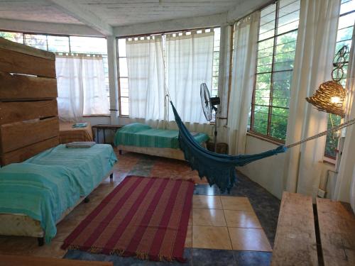 a bedroom with a hammock in a room with windows at Scenario Yguazu in Puerto Iguazú