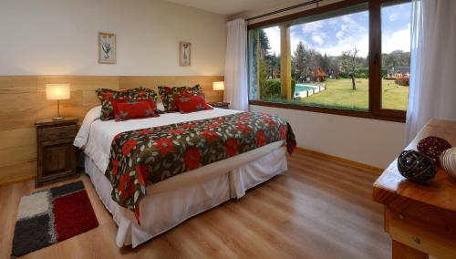 a bedroom with a large bed and a large window at La Estancia Cabañas in Villa La Angostura