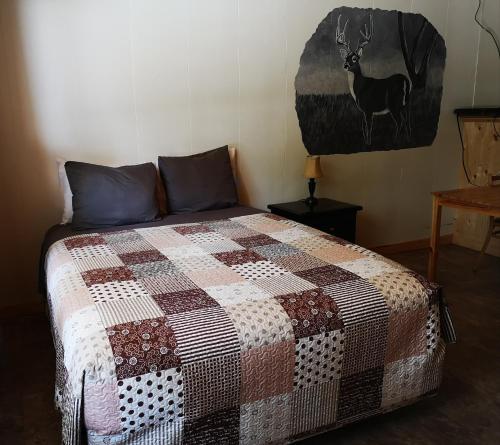 a bed with a quilt on it in a room at Overlook Inn & Cabins in Clearwater