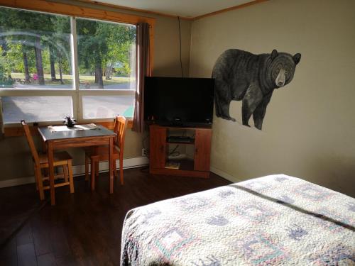 a bedroom with a bear painting on the wall at Overlook Inn & Cabins in Clearwater