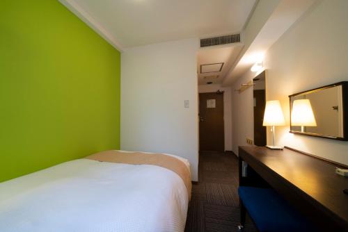 a bedroom with a bed and a green wall at Hotel S-plus Nagoya Sakae in Nagoya