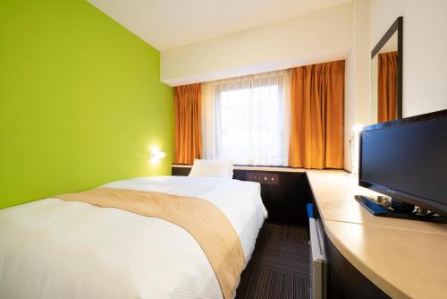 名古屋市にあるホテルエスプル名古屋栄のベッド1台、薄型テレビが備わるホテルルームです。