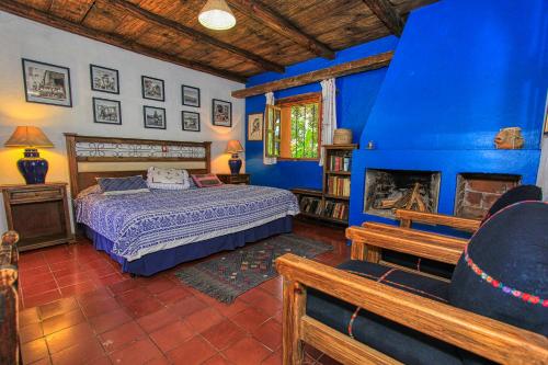 1 dormitorio con cama y pared azul en Hotel Na Bolom en San Cristóbal de Las Casas
