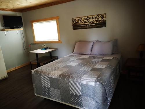 a bedroom with a bed and a window and a table at Overlook Inn & Cabins in Clearwater