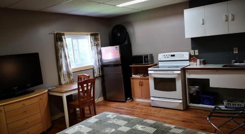 a kitchen with a stove and a refrigerator and a table at Overlook Inn & Cabins in Clearwater