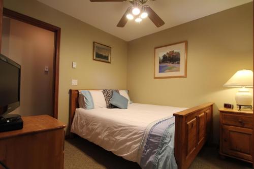 sypialnia z łóżkiem i telewizorem z płaskim ekranem w obiekcie Lagoons Condos by Whistler Retreats w mieście Whistler
