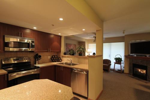 a kitchen with wooden cabinets and a stove top oven at Lagoons Condos by Whistler Retreats in Whistler