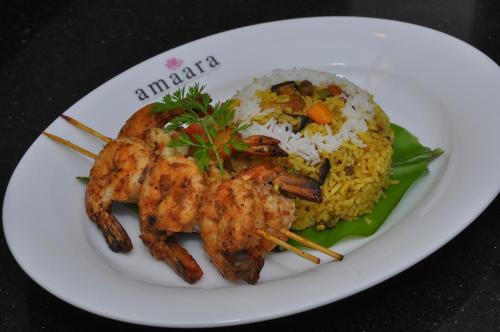 a white plate of food with shrimp and rice at Amaara Sky Hotel Kandy in Kandy