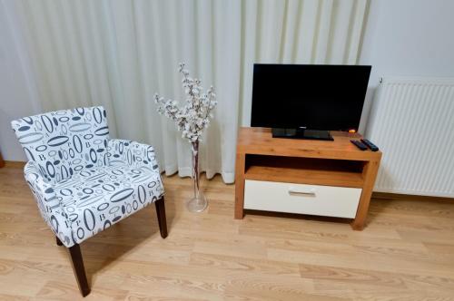 a living room with a tv and a chair and a table at Upart Home in Mersin