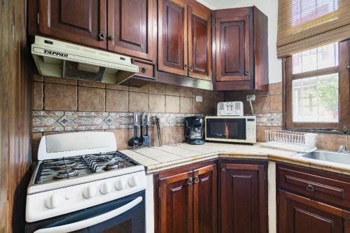a kitchen with wooden cabinets and a stove top oven at Villas Santa Ana-Ricardo in Antigua Guatemala