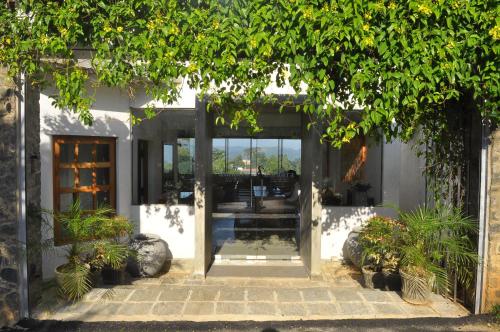an open door of a white building with plants at Amaara Sky Hotel Kandy in Kandy