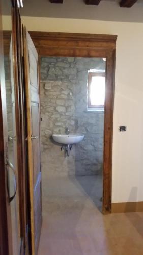 a bathroom with a sink and a stone wall at B&B Marcantonio Country House in Sogliano al Rubicone