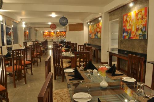 a restaurant with a dining room with tables and chairs at Amaara Sky Hotel Kandy in Kandy