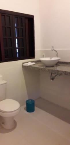 a bathroom with a white toilet and a sink at Apartamentos de Férias por Temporada Martim De Sá in Caraguatatuba
