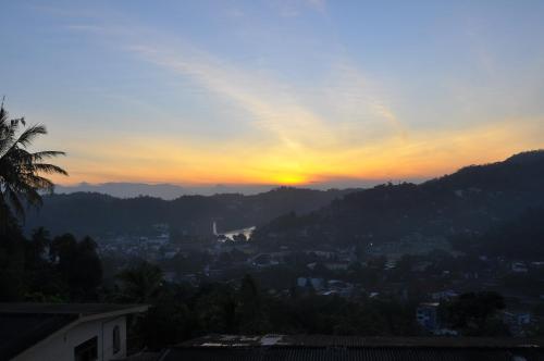 a sunset with the sun setting over a city at Amaara Sky Hotel Kandy in Kandy