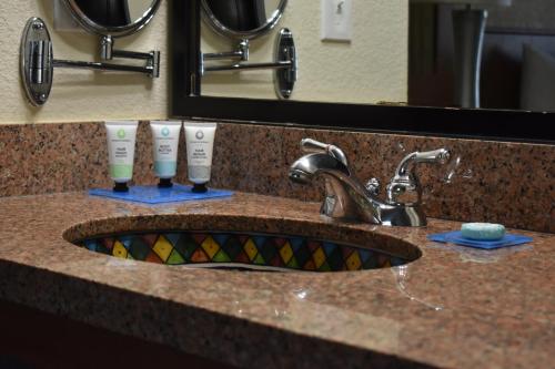 a bathroom sink with two toothbrushes and a mirror at Studio 6 Carlsbad CA in Carlsbad