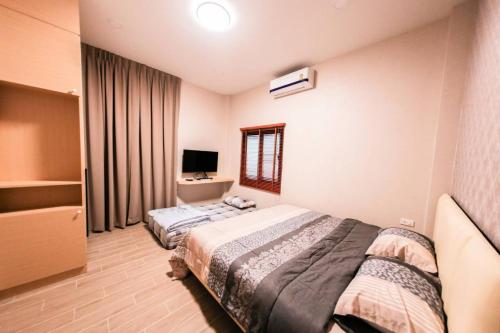 a hotel room with two beds and a television at Uzeason Poolvilla Sattahip in Sattahip