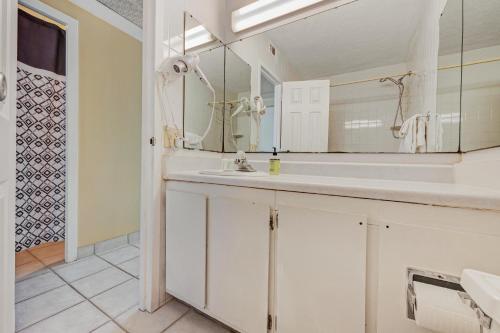 a white bathroom with a sink and a mirror at The Top of the Gulf #112 in Panama City Beach
