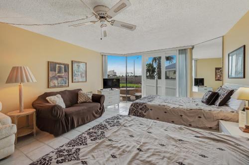 a living room with two beds and a couch at The Top of the Gulf #112 in Panama City Beach