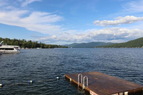 a dock on a lake with a boat in the water at The Lake Motel in Lake George