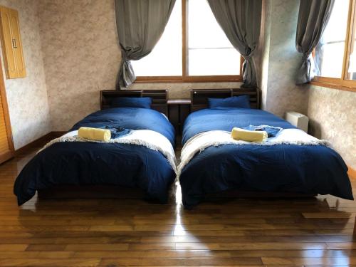two beds sitting next to each other in a bedroom at Apartment at Toemu Nozawa in Nozawa Onsen