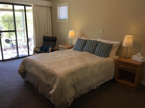 a bedroom with a large bed and a balcony at Rickaty on Blackwood in Bridgetown