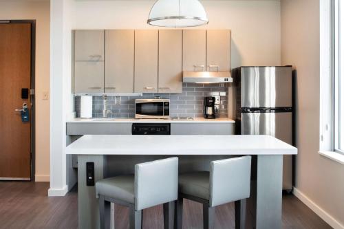 a kitchen with a white counter and a refrigerator at Hyatt House East Moline/Quad Cities in East Moline
