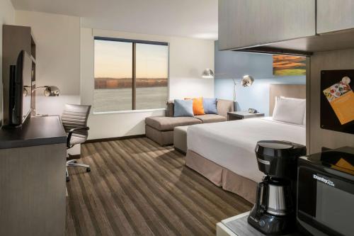 a hotel room with a bed and a couch at Hyatt House East Moline/Quad Cities in East Moline