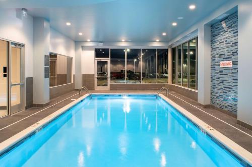 a large swimming pool with blue water in a building at Hyatt House East Moline/Quad Cities in East Moline