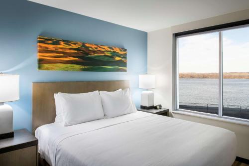 a bedroom with a large bed and a large window at Hyatt House East Moline/Quad Cities in East Moline