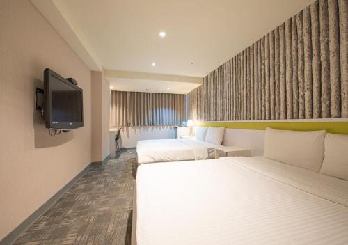 um quarto de hotel com duas camas e uma televisão de ecrã plano em 9ine Hotel em Taipei